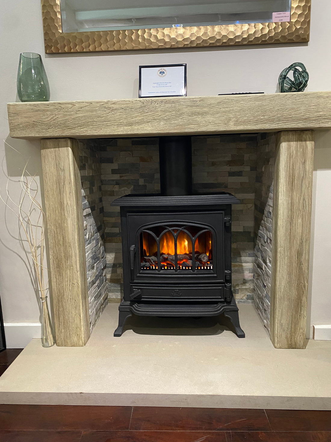A cozy fireplace with a black electric stove insert, surrounded by a stone and wood mantel, creating a warm and inviting home heating focal point.