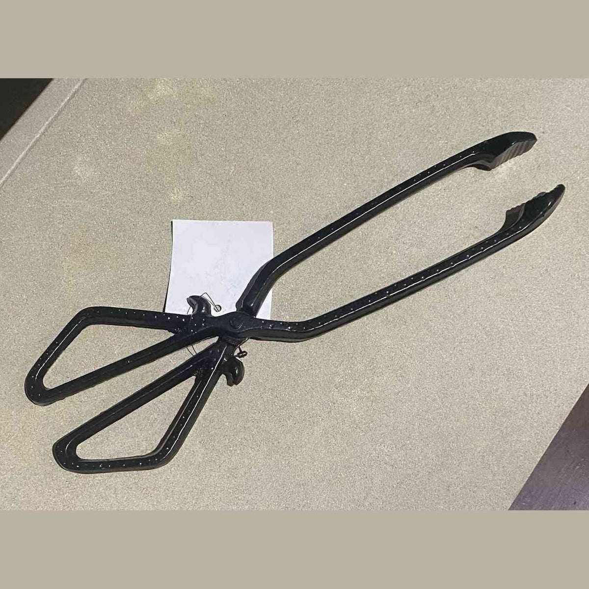 Black cast iron coal tongs with scissor-action pivot and loop handles