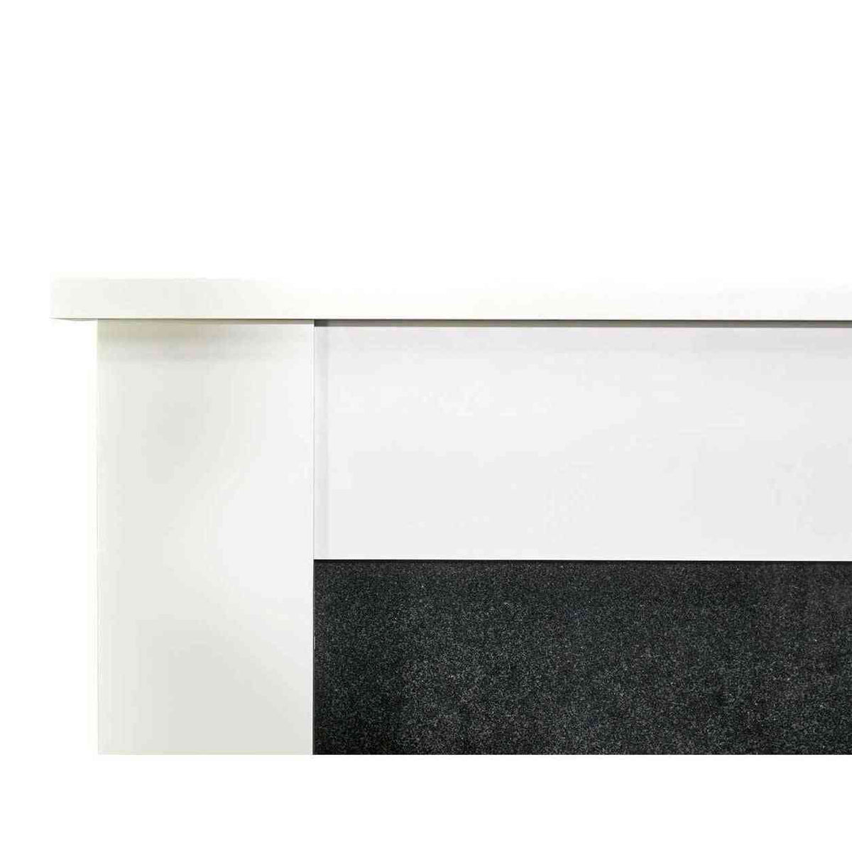 Close-up of glossy white wooden mantel edge meeting speckled black granite fireplace