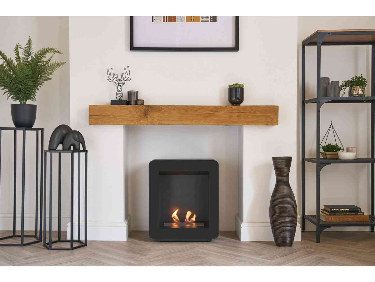 Interior scene with a black bio ethanol stove, wooden mantel, and decorative plants, creating a cozy home ambiance