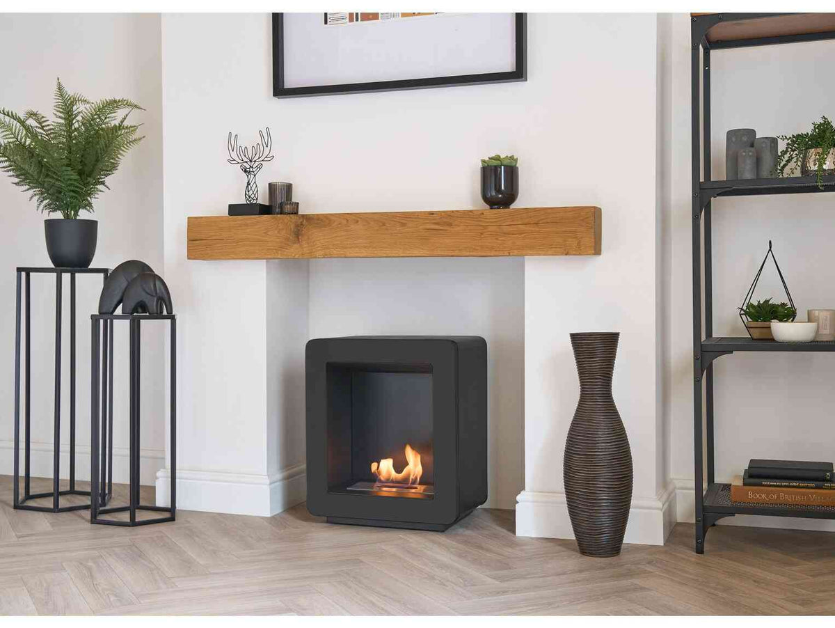 Modern black bio ethanol stove with a sleek square design and visible flames, placed in a stylish living room with decorative items