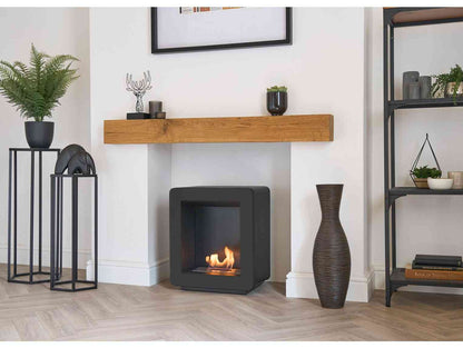 Modern black bio ethanol stove with a sleek square design and visible flames, placed in a stylish living room with decorative items