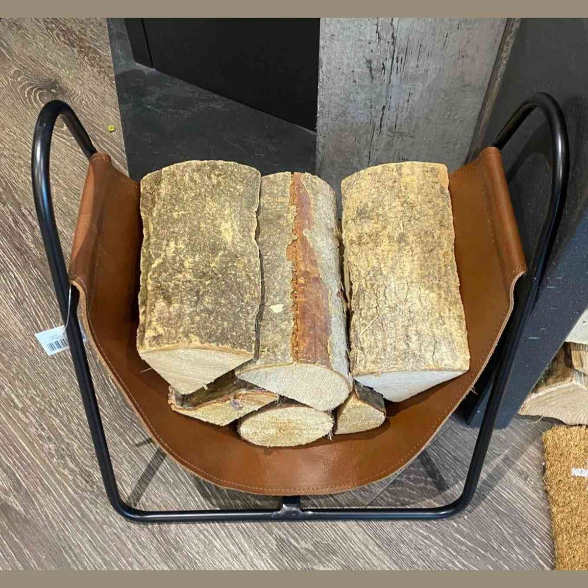 Top view of Apache brown leather log storage basket filled with stacked wood logs