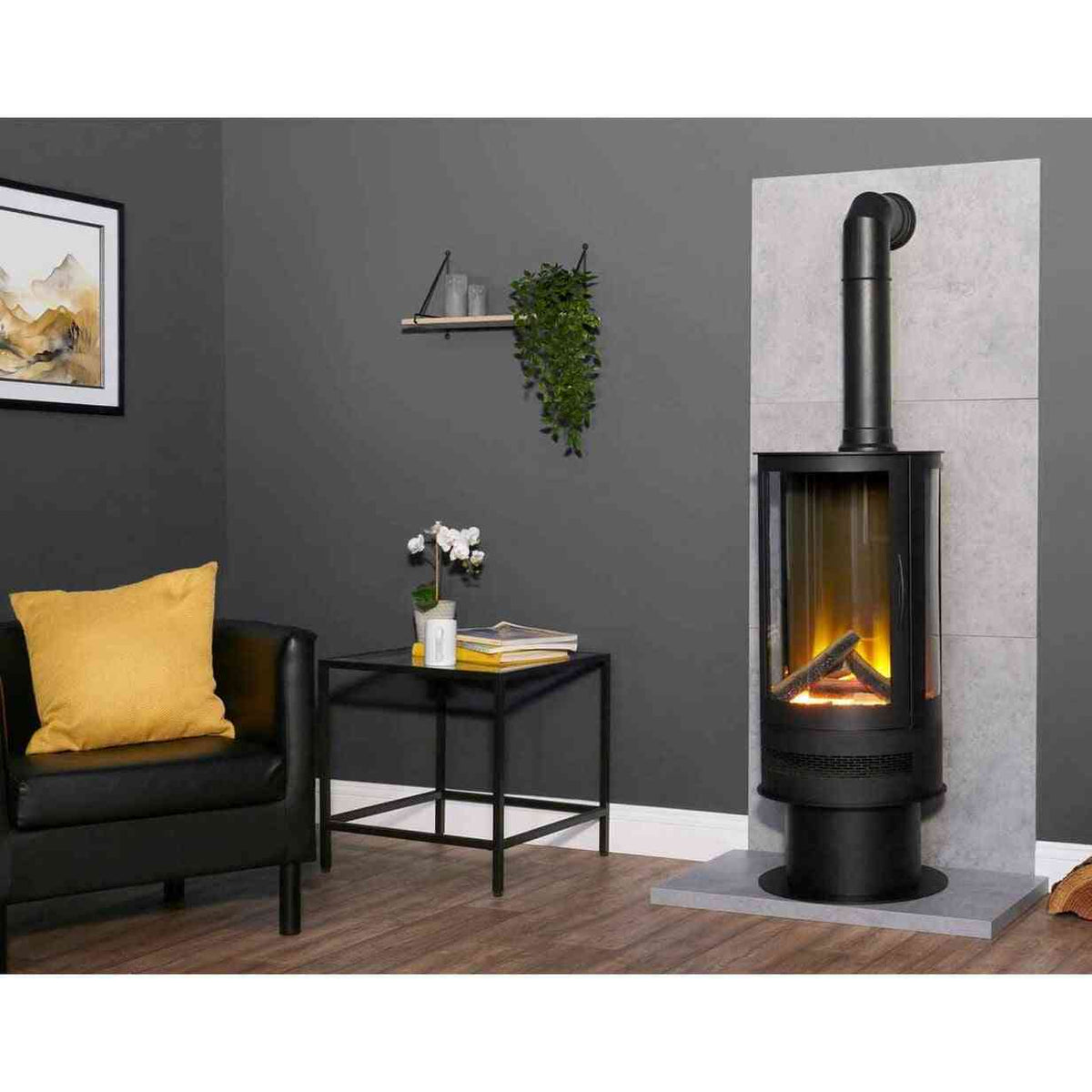 Freestanding black cylinder stove with 3-sided glass front and vertical flue pipe in contemporary setting