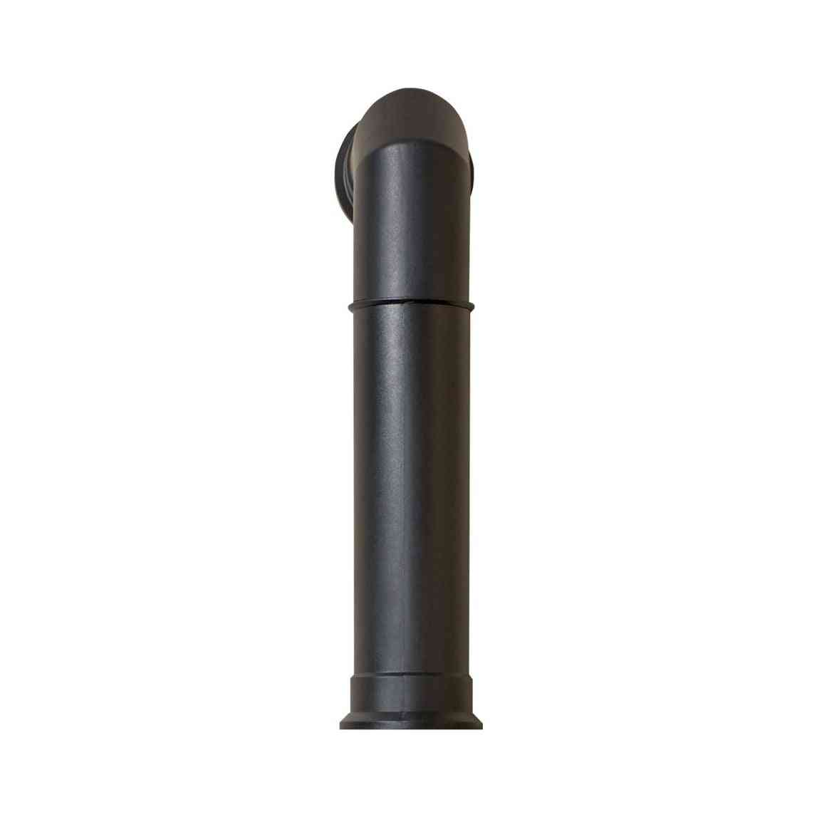 Close-up of matte black molded plastic stove pipe with flared base and angled top design