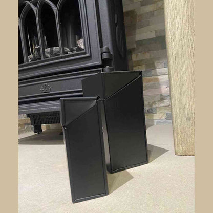 Modern black fireside organizer set beside wood burning stove showing diagonal cutout