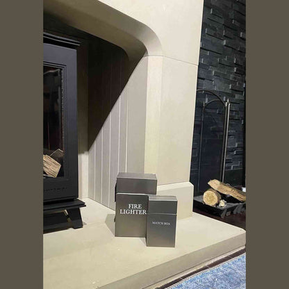 Closed brushed silver fire accessories set beside wood burning stove