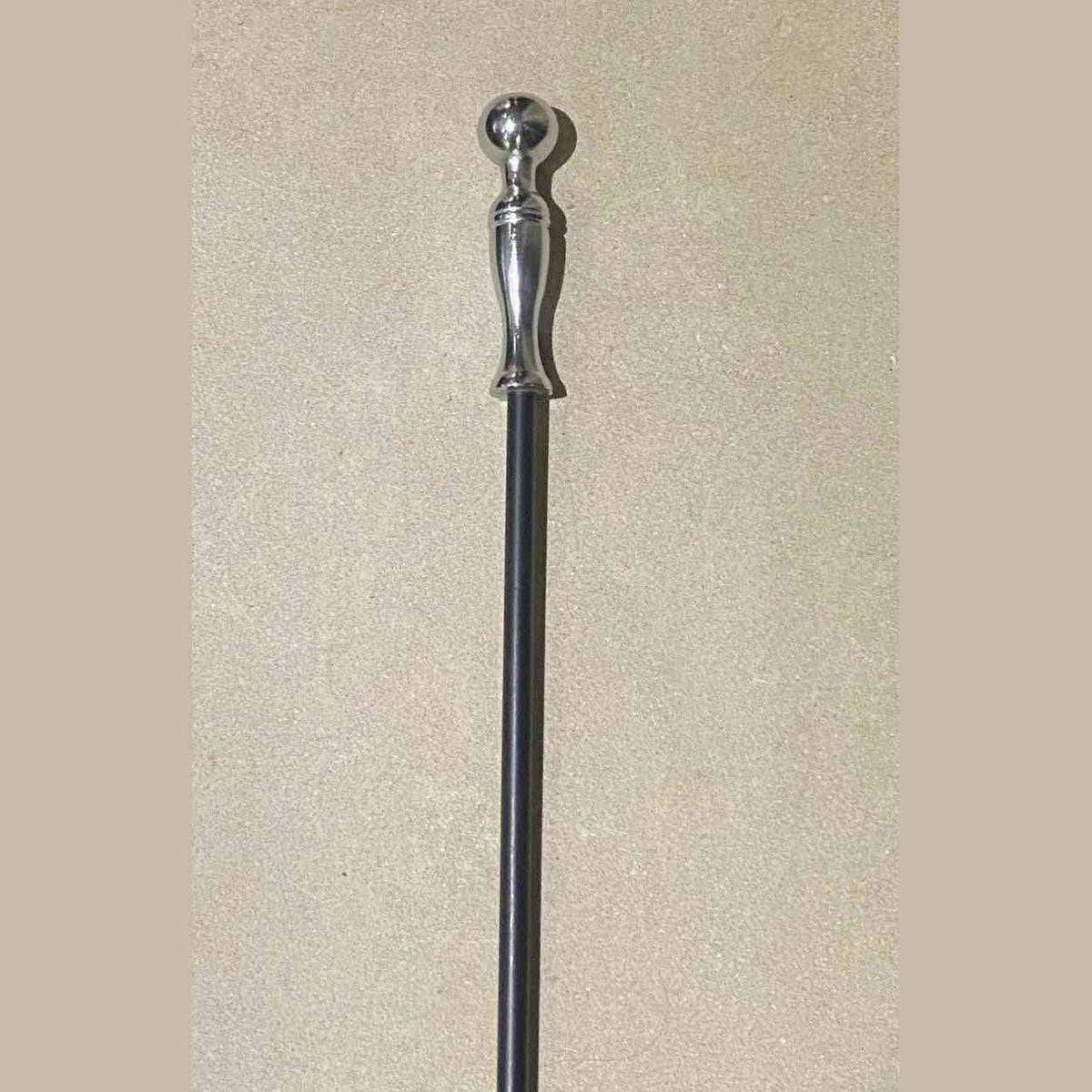 Close-up of polished chrome spherical knob and flared handle on Calfire fireplace tool