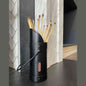 Black Calfire match canister on dark countertop beside herringbone tile fireplace