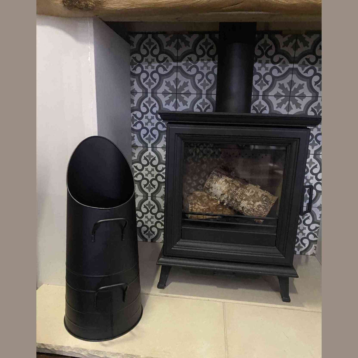 Calfire Dryton black metal coal scuttle with dual handles on stone hearth
