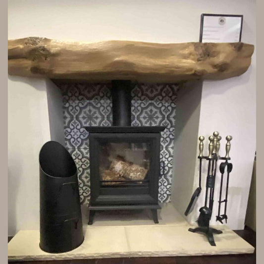 Black Calfire coal bucket beside wood stove and fireplace tools set