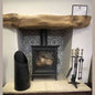Black Calfire coal bucket beside wood stove and fireplace tools set