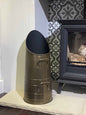  Close-up view of the 53.5cm Calfire Dryton antique hod coal bucket sitting on a light stone hearth next to a traditional fireplace stove.