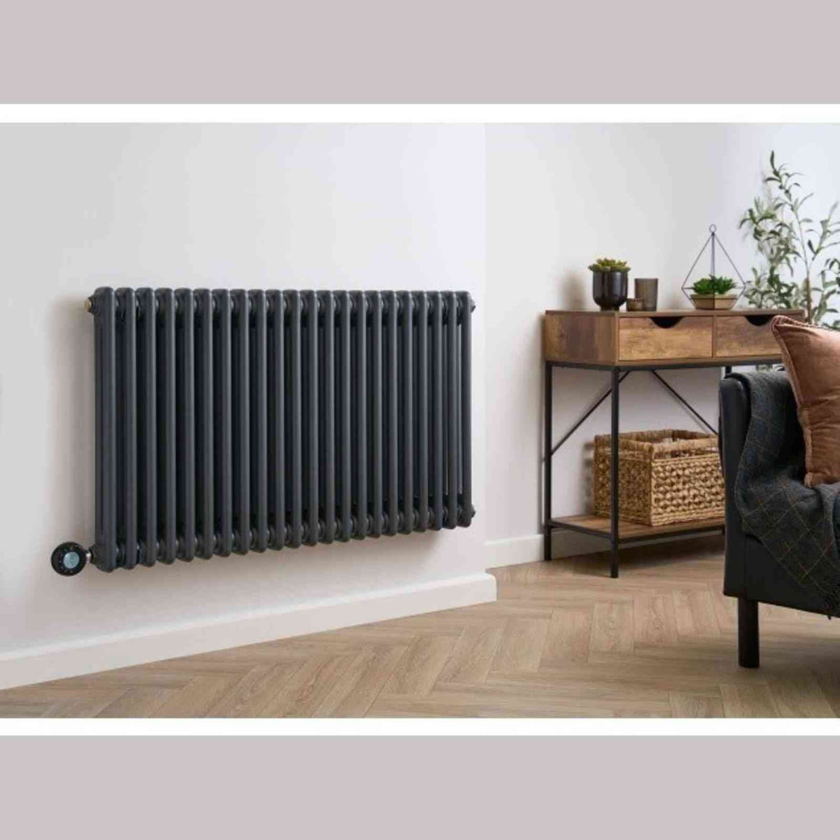 Anthracite column radiator mounted on white wall in living room with digital controls
