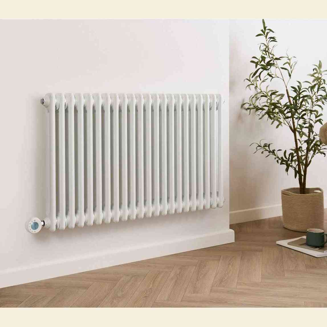 White wall-mounted electric radiator showing blue LCD digital thermostat display