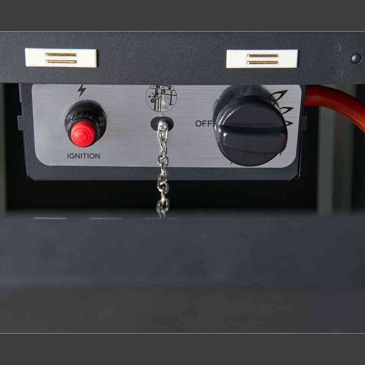 Close-up of black propane heater control panel with red ignition button and rotary knob