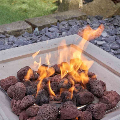 Low-angle close-up of burning flames and lava rocks inside square fire pit
