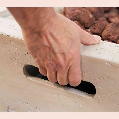 Close-up of ergonomic recessed handle on textured concrete fire pit side