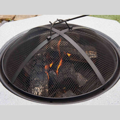 Close-up of black mesh lid over glowing embers in concrete fire pit