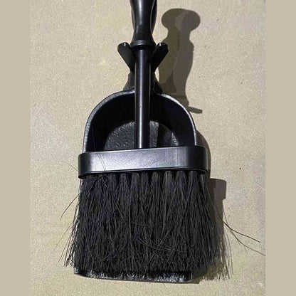 Detail view of cast iron hearth brush nestled in shovel bowl