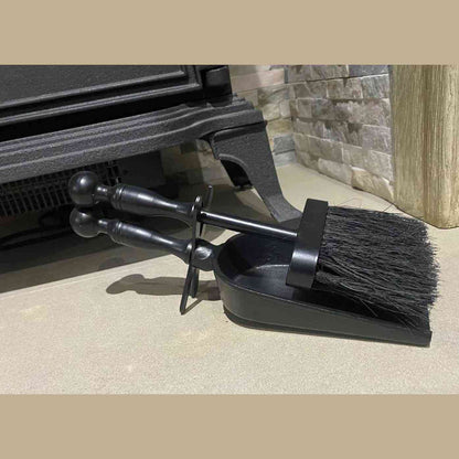 Cast iron fireplace tools mounted together beside stove