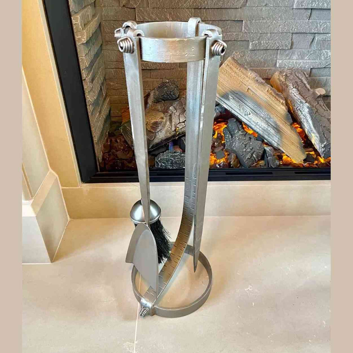 Curved stand fireplace tool set with poker shovel and brush displayed near electric fireplace