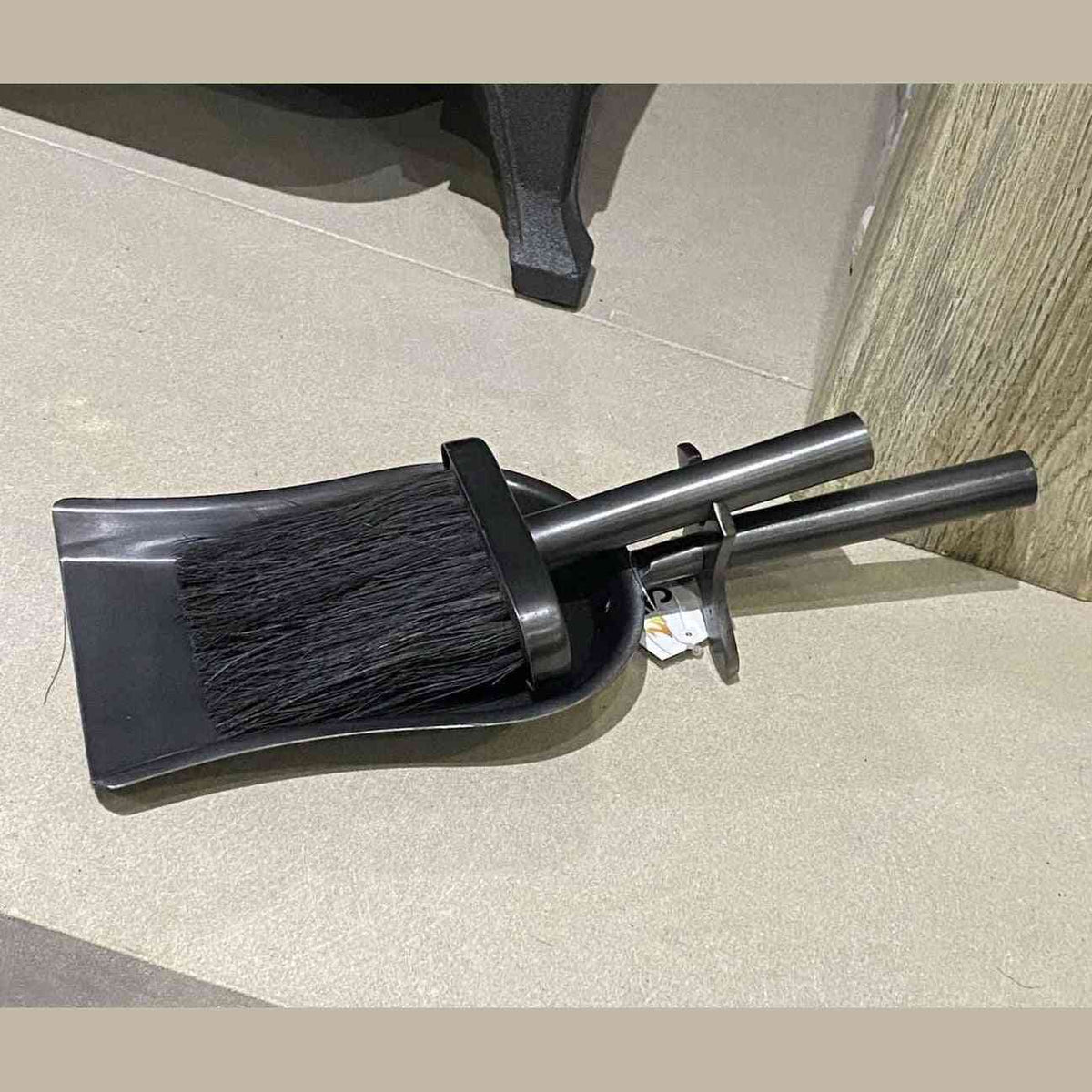 Side angle of Mortimer galvanised brush and shovel set near fireplace leg