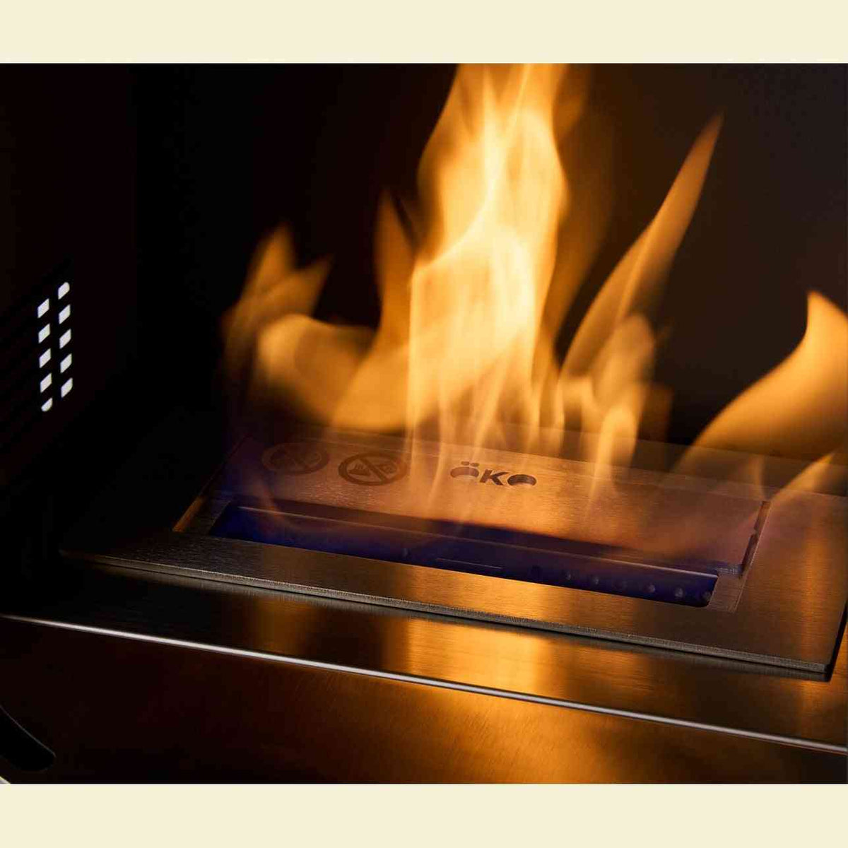 Active orange-yellow flame in brushed stainless steel burner tray of OKO S5 bio ethanol cylinder stove