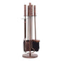 Antique copper fireplace toolset with four tools including a poker, tongs, brush, and shovel, standing on a round base for fireside convenience.