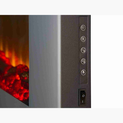 Hand holding remote control with buttons for power, heat, temperature, and flame settings, used to operate the electric fireplace.
