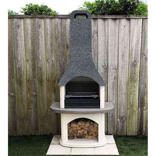 Woodford Sorrento outdoor stone barbecue installed on grass with firewood storage