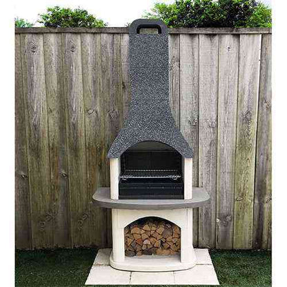 Woodford Sorrento outdoor stone barbecue installed on grass with firewood storage